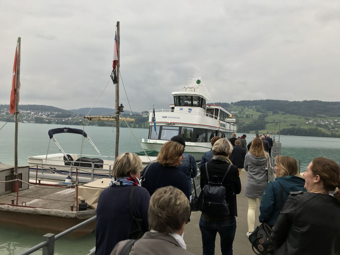 Eine Gruppe wartet an der Anlegestelle auf das Kursschiff auf dem Hallwilersee.